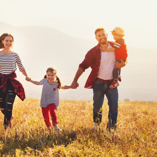 Happy family: mother, father, children son and daughter on sunset